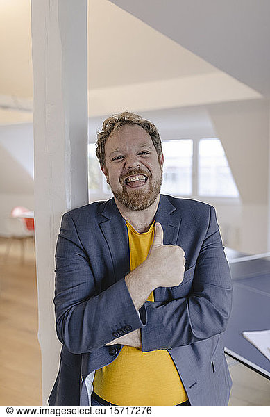 Portrait of a happy businessman in office with table tennis table