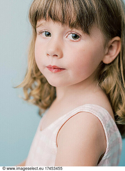 Portrait of a little girl on a pastel blue background