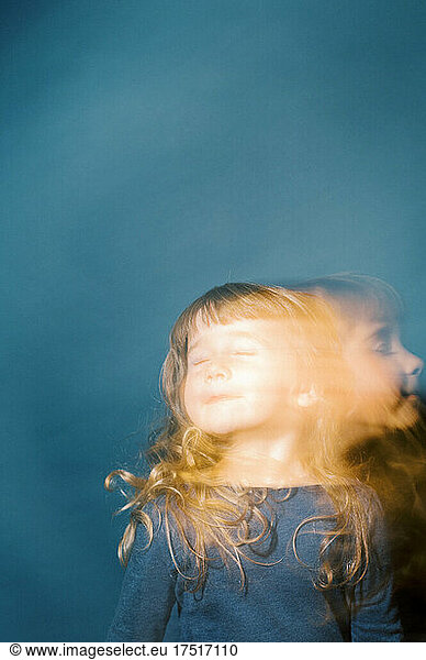 Portrait of a little toddler girl in golden light with slow shutter