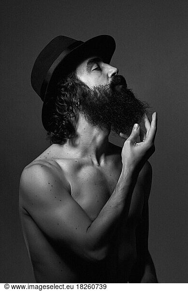 Portrait of a man with beard and hat naked. Shirtless. black and white