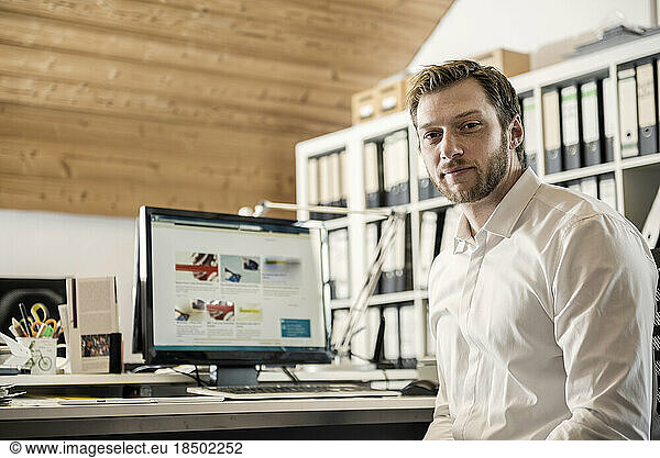 Portrait of a mid adult businessman working on computer in an office  Bavaria  Germany