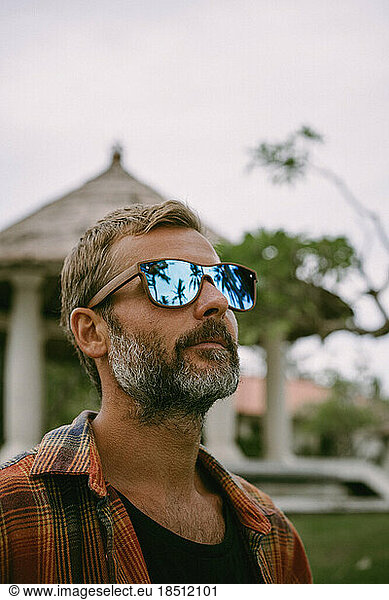 Portrait of a middle-aged man in mirrored sunglasses. reflection