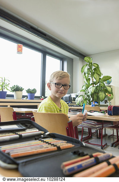 Portrait of a schoolboy sitting in classroom  Munich  Bavaria  Germany