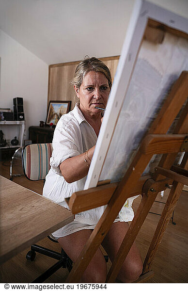 Portrait of a senior woman painting a picture.
