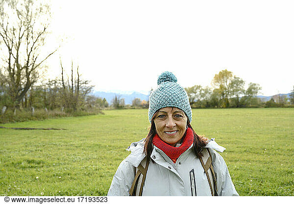 Portrait of a smiling backpacker woman with wool hat  looking camera
