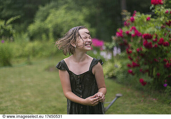 Portrait of a smiling girl in the rain in the garden.