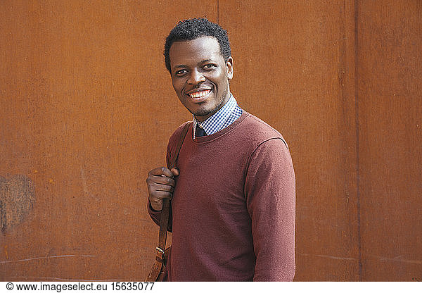 Portrait of a smiling young man  carrying bag