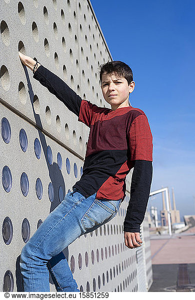 Portrait of a teen hanging up on wall while looking to camera