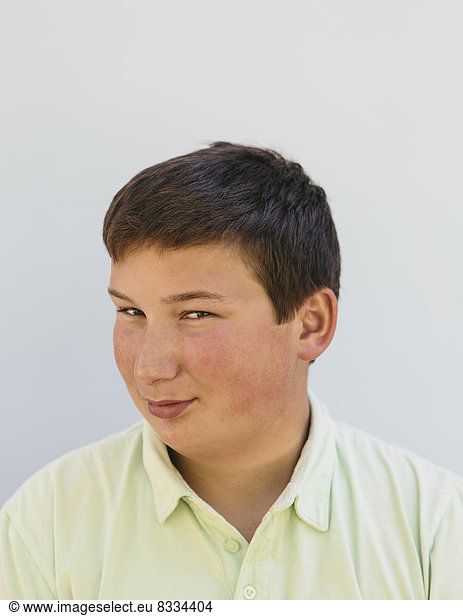 Portrait of a teenage boy with short black hair  looking at the camera and smiling.