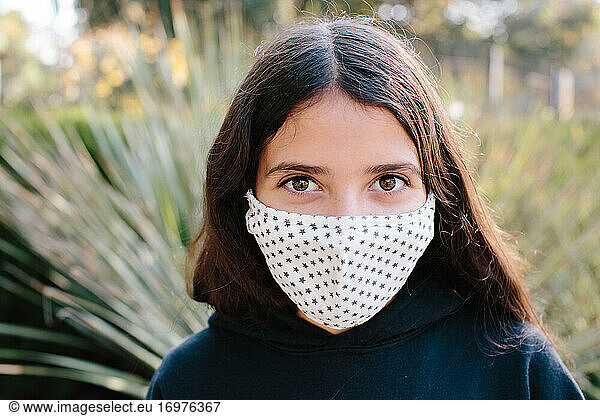 Portrait Of A Tween Girl Wearing A Cloth Face Mask With A Star Pattern