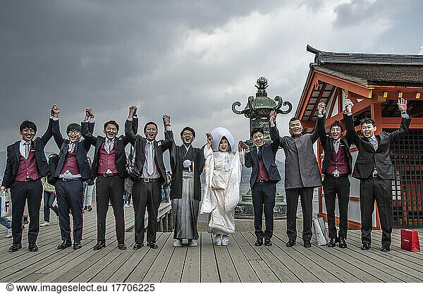 Portrait of a wedding party posing for the camera in celebration on Naoshima  an island in the Seto Inland Sea that is known for its modern art museums  architecture and sculptures. Much of Naoshima's art was installed by the Benesse Corporation  which oversees art museums  installations and sculptures both on Naoshima and on neighboring islands; Naoshima  Shikoku  Japan