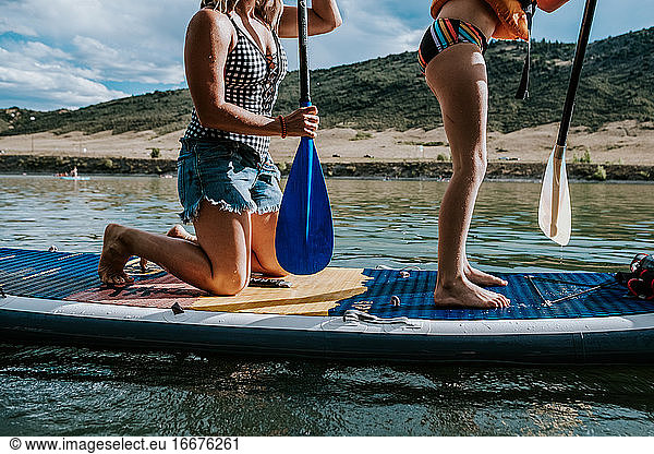 portrait of a woman and young girl on a paddle board on a sunny day