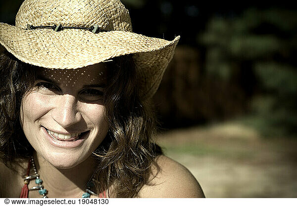 Portrait of a woman in cowboy hat and bikini outdoors.