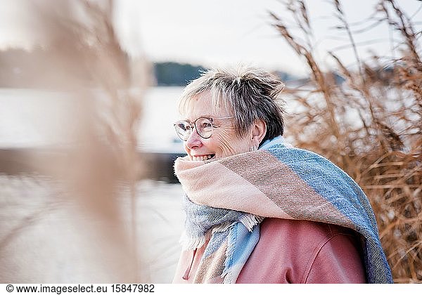 portrait of a woman in her 60's smiling looking happy at the beach