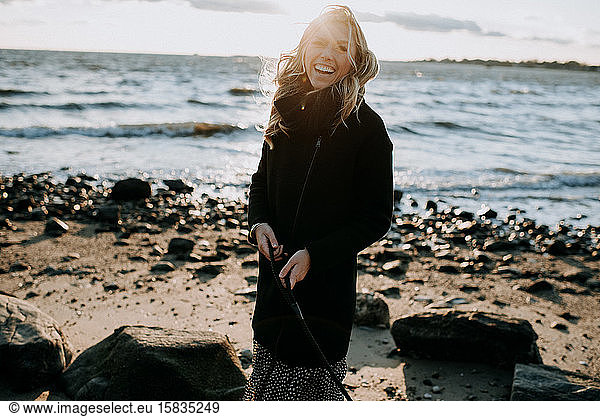 portrait of a woman laughing on the beach in wintertime