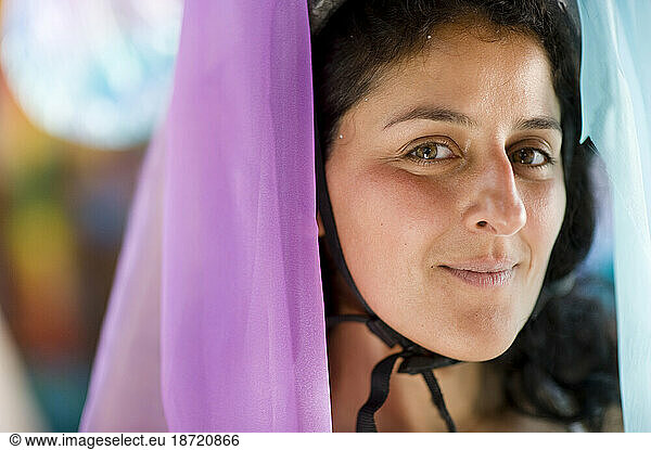 Portrait of a woman preparing for a parade in Santa Barbara. The parade features extravagant floats and costumes.