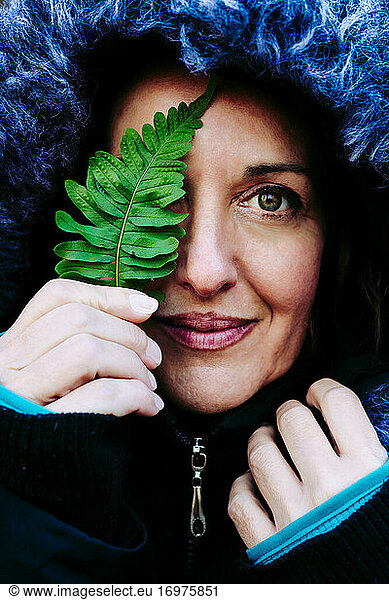 portrait of a 45-year-old woman with a fern leaf