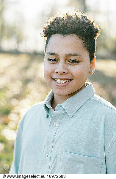 Portrait of a young boy outdoors smiling into the camera