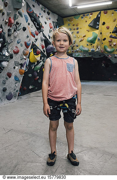 Portrait of a young boy wearing rock climbing harness  smiling at camera.