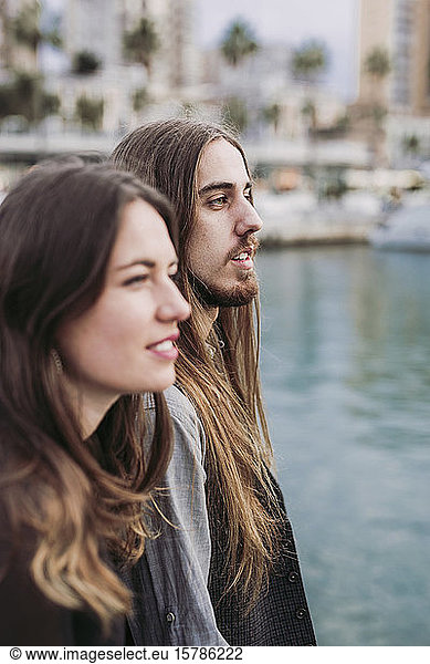 Portrait of a young couple at a marina looking out