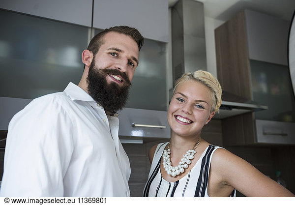 Portrait of a young couple standing in the kitchen