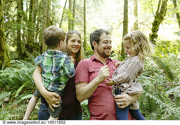 Portrait of a young family of four in the forest