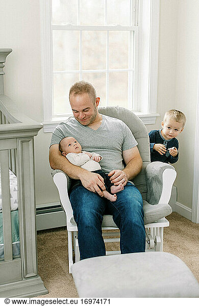 Portrait of a young father and his newborn baby boy and toddler