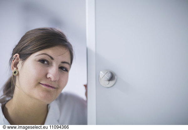 Portrait of a young female doctor at door in hospital