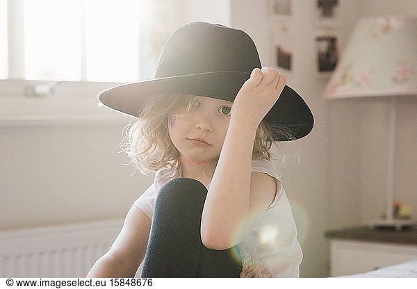portrait of a young girl holding her hat with her face painted