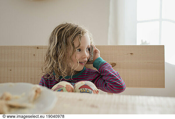 portrait of a young girl sat at home using a mobile phone