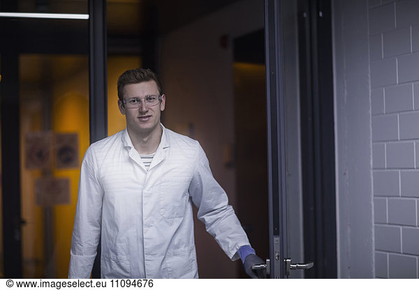 Portrait of a young male scientist working in an optical laboratory