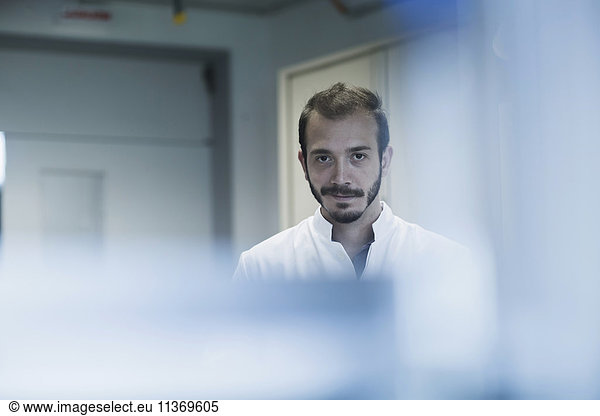 Portrait of a young male scientist working in technology space