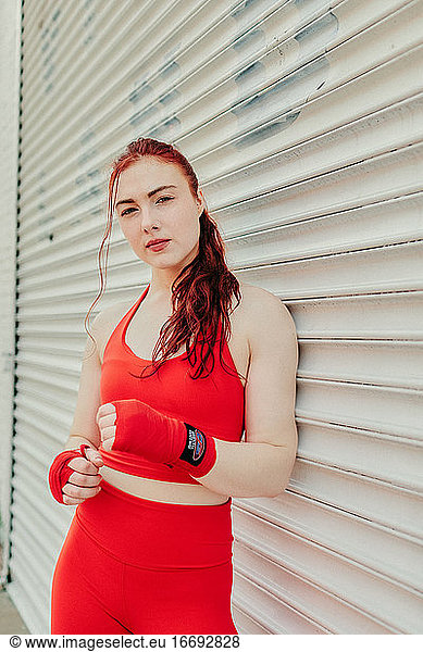 Portrait of a young woman boxer training outdoors in Brooklyn street.