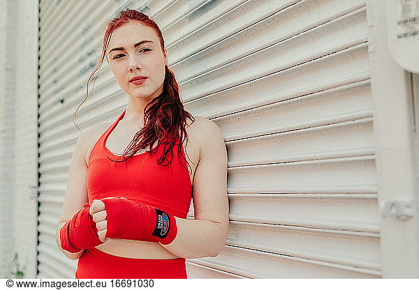 Portrait of a young woman boxer training outdoors in Brooklyn street