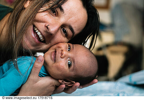Portrait of a young woman smiling with her baby.
