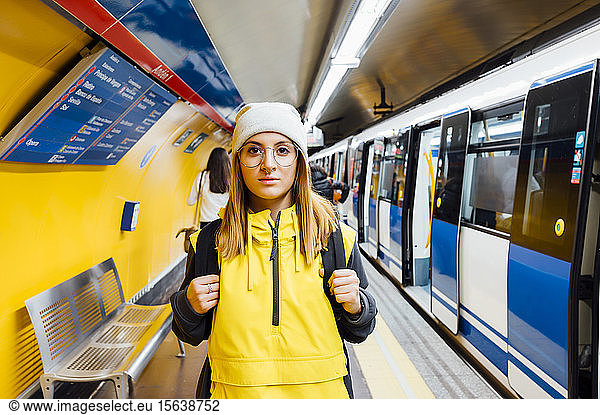 Portrait of a young woman standing on underground station platform