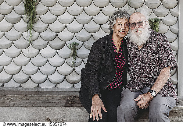 Portrait of active senior couple sitting and smiling outside