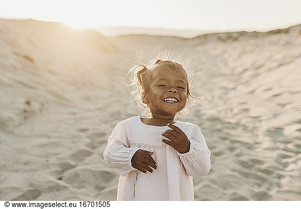 Portrait of adorable young girl at beach during sunset