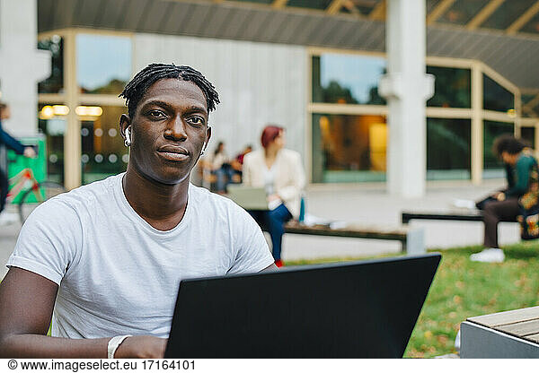 Portrait of African male student with laptop in university