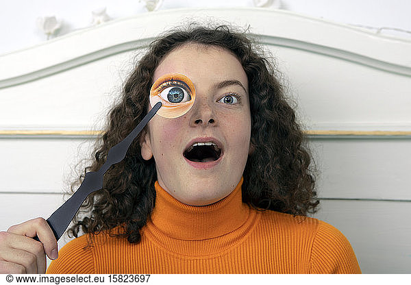 Portrait of amazed young woman with paper mask