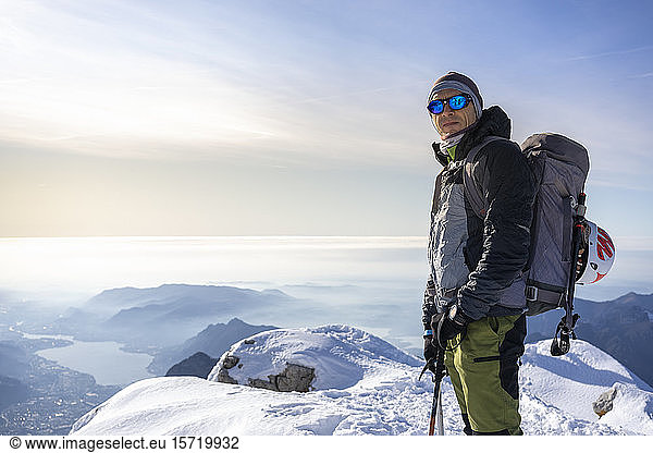Portrait of an alpinist standing on snowy mountain peak  Orobie Alps  Lecco  Italy