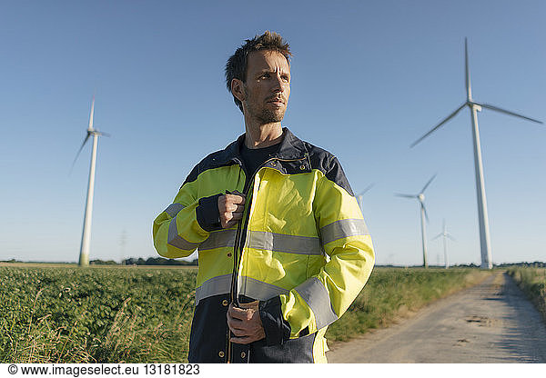 Portrait of an engineer on field path at a wind farm