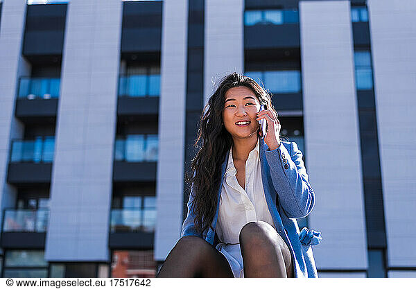 Portrait of Asian businesswoman talking on her mobile phone.