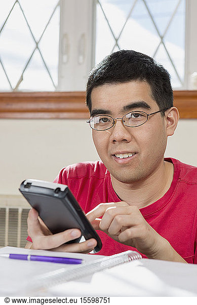 Portrait of Asian man with Autism working on his cell phone