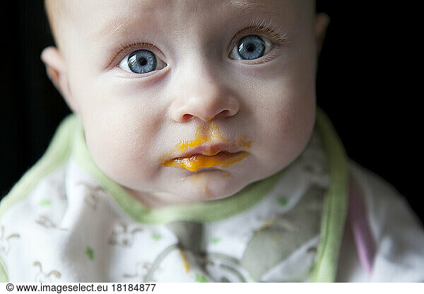 Portrait of baby boy against black background  close up