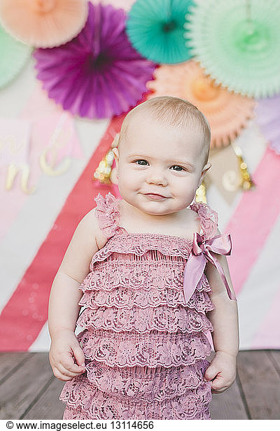 Portrait of baby girl against decoration at birthday party