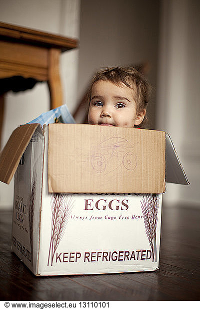 Portrait of baby girl sitting in sitting in box