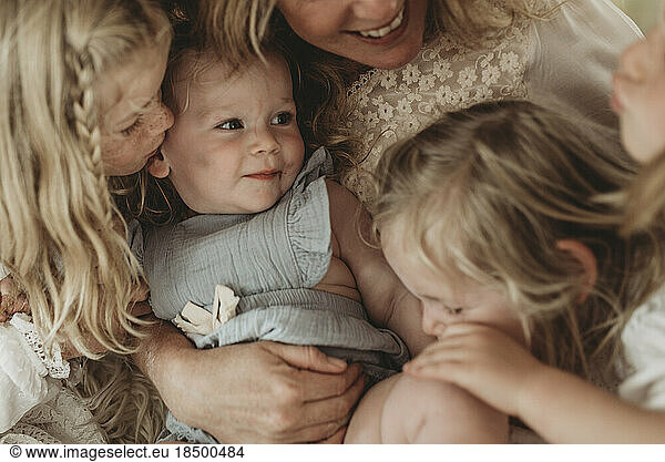 Portrait of baby girl while surrounded by sisters and mother