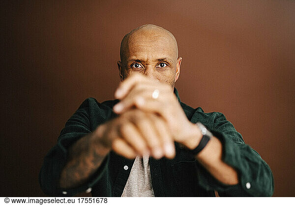 Portrait of bald mature man gesturing in studio