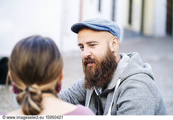 Portrait of bearded man looking at woman in the city